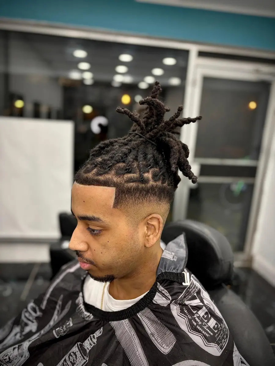Locs styled high with a fade