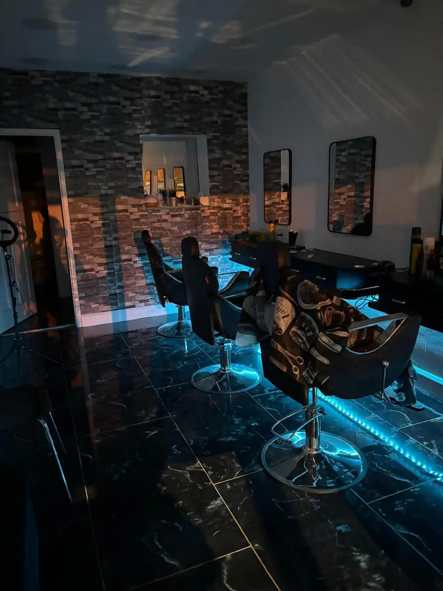 HT Hair Studio at night with lit styling chairs